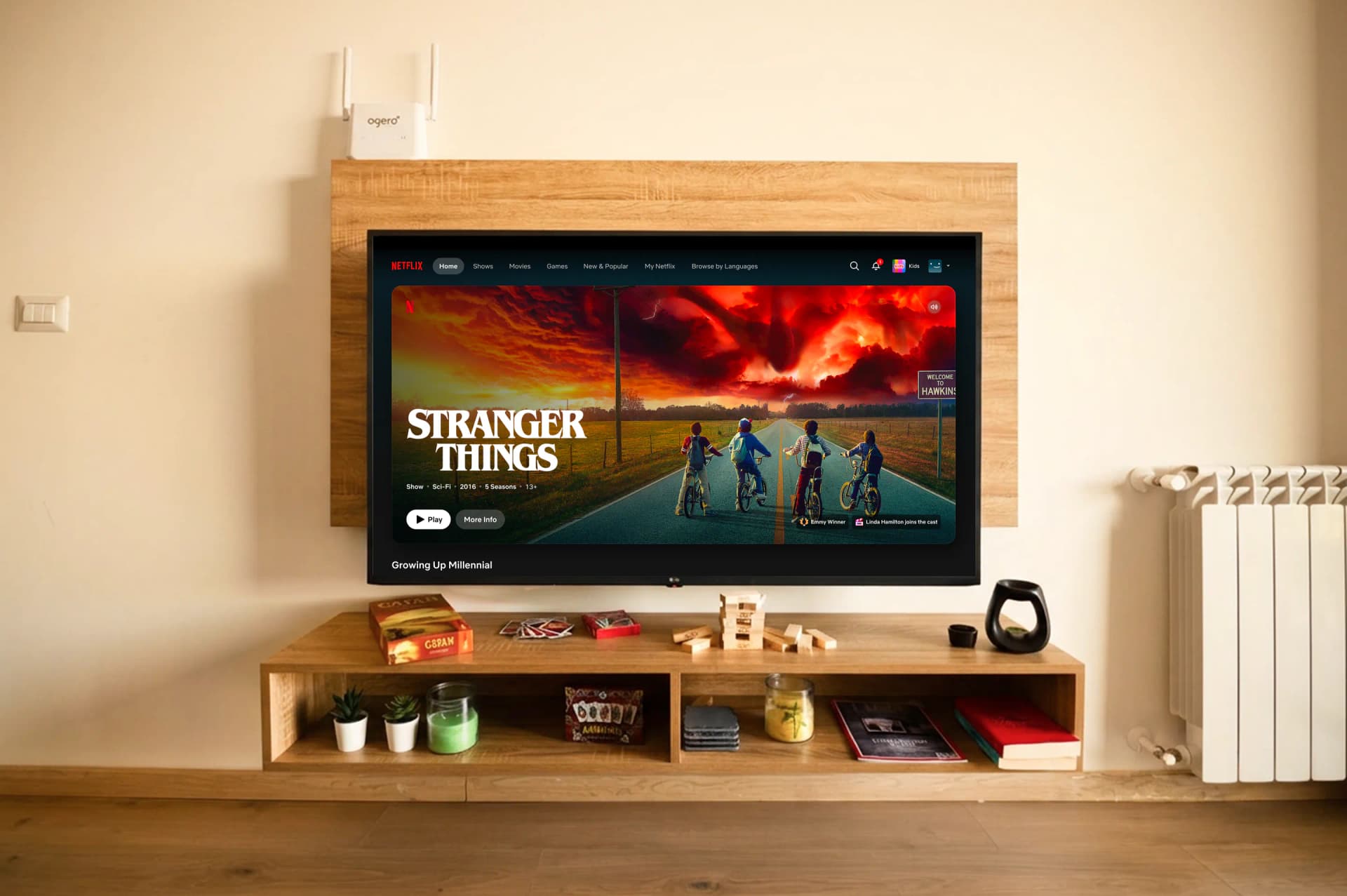 The TV wall with board games and books on the shelf, the radiator beside it