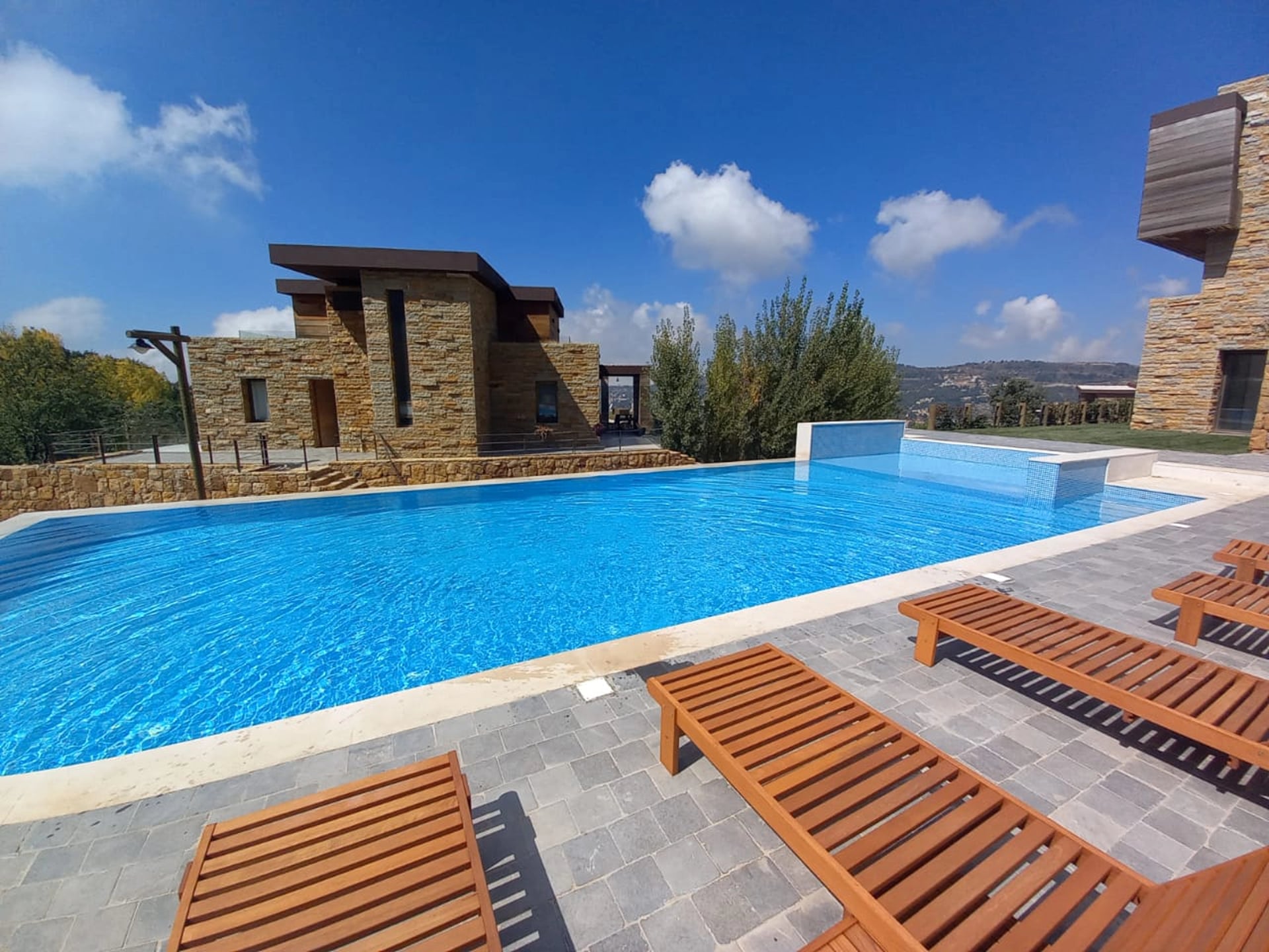The chalets and infinity pool at RedRock Faqra in summer